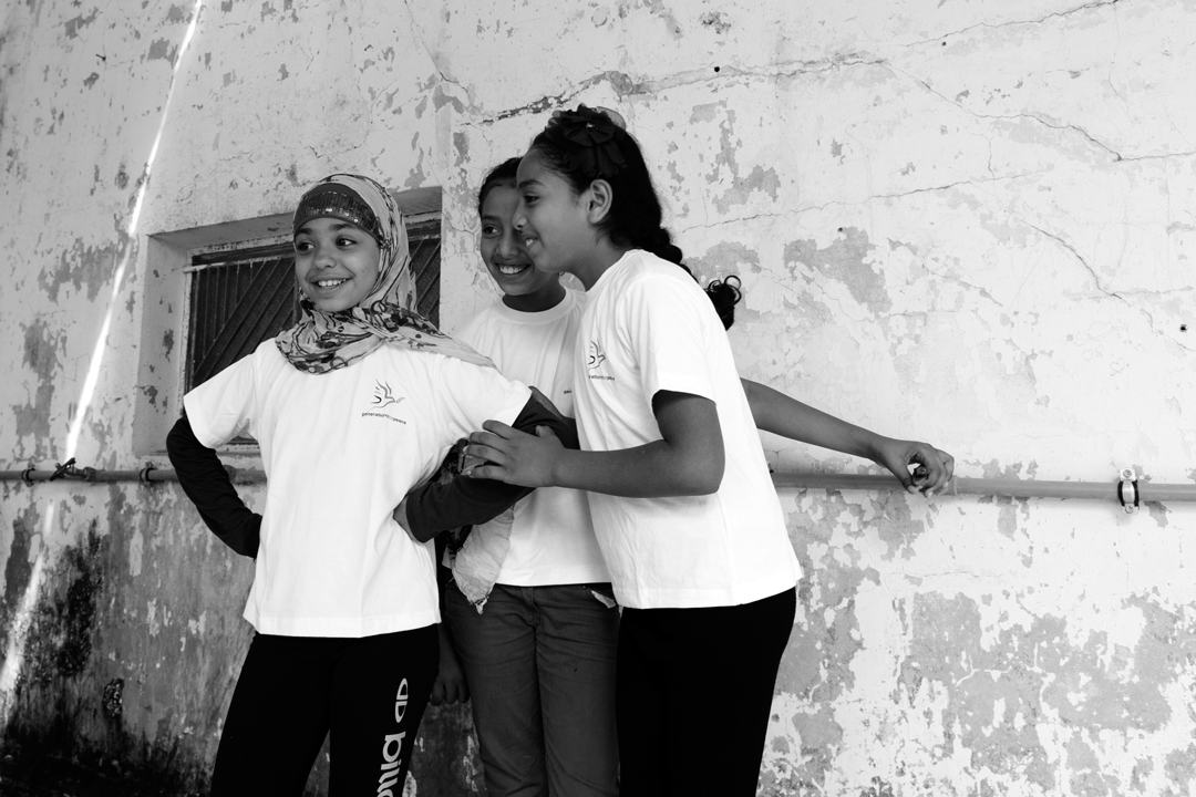 young girls smiling wearing Generations for Peace t-shirts